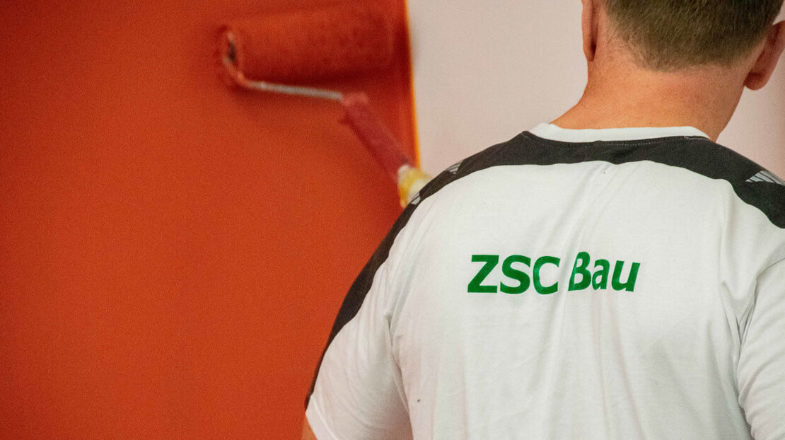 Ein Mitarbeiter der ZSC gGmbH streicht eine Wand.