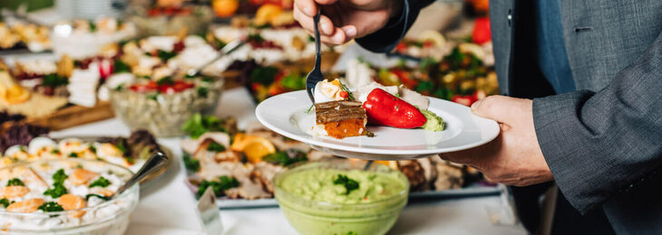 Ein Mann bedient sich bei einem großen vielseitigen Buffet