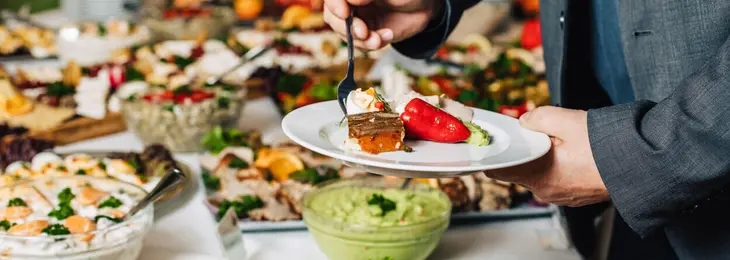 Ein Mann bedient sich bei einem großen vielseitigen Buffet