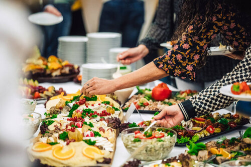 Mehrere Personen bedienen sich am Buffet mit verschiedenen Zutaten