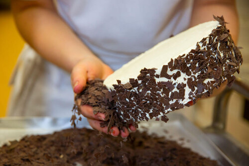 Eine Torte wird mit Schokostücken verziert.