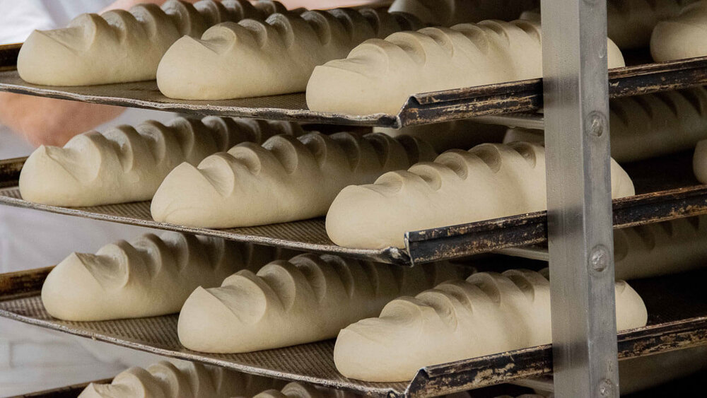 Frisch zubereitete Brotlaibe liegen in einem Regal