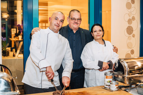 Zwei Mitarbeitende in Küchenkleidung am Buffet