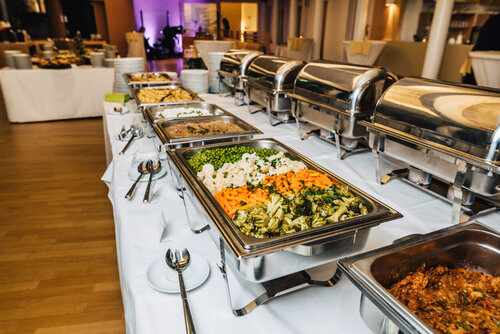 Mehrere Platten mit verschiedenen Gemüsen, Fleisch und anderen warmen Gerichtne